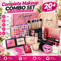 A complete makeup combo set displayed on a white surface with decorative pink floral elements in the background. The set includes a pink makeup combo box, a beige drawstring bag, an eyeshadow palette, brushes, face powders, lip products, mascara, false eyelashes, and other beauty essentials.
