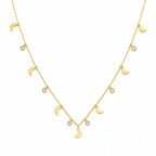 A delicate gold necklace featuring a series of small moon phases and clear round gemstones on a clean white background.