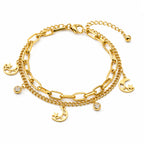 A gold-toned multi-layer bracelet featuring a combination of paperclip and curb chains with dangling crescent moon and star charms, along with two small clear crystal charms, shown on a plain white background.