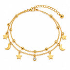 A double-layered gold chain anklet featuring star and crescent moon charms, polished gold beads, and a central clear rhinestone charm, displayed on a clean white background.