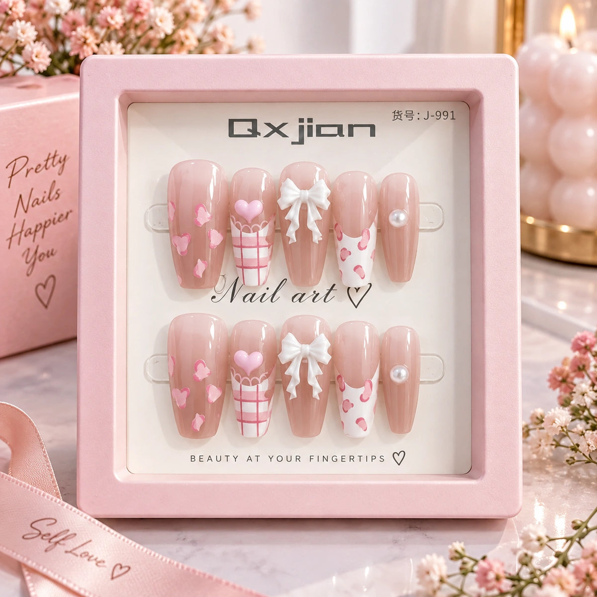 A set of six decorative press-on nails displayed in a pink box. The nails have a glossy nude-pink base with pink hearts, plaid patterns, white bows, and white pearl accents.
